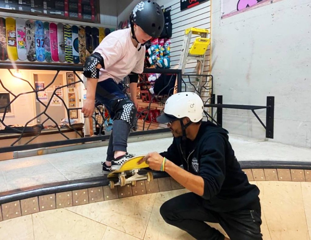 Dicas sobre skate para iniciantes 2 Homem ensinando menino a subir no skate